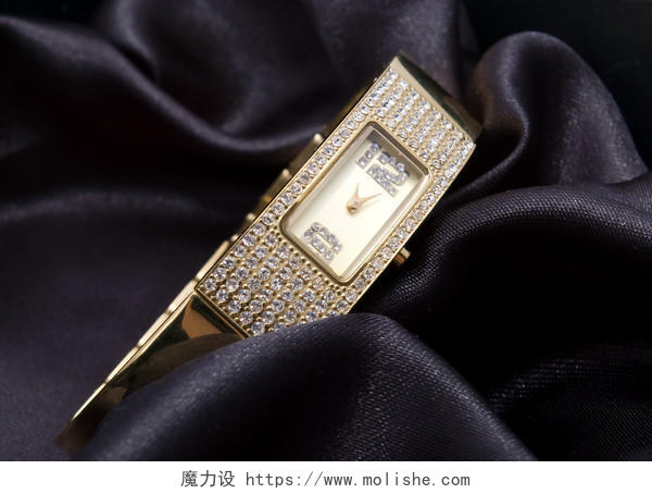 黑色丝绸背景上的金色手表